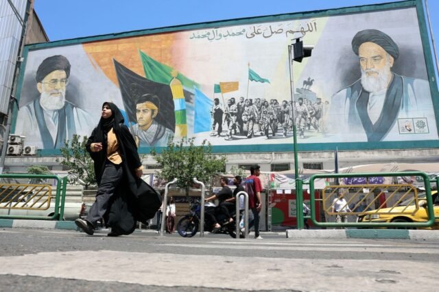 1779243713_2439140-des-iraniens-passent-devant-une-affiche-representa.jpg