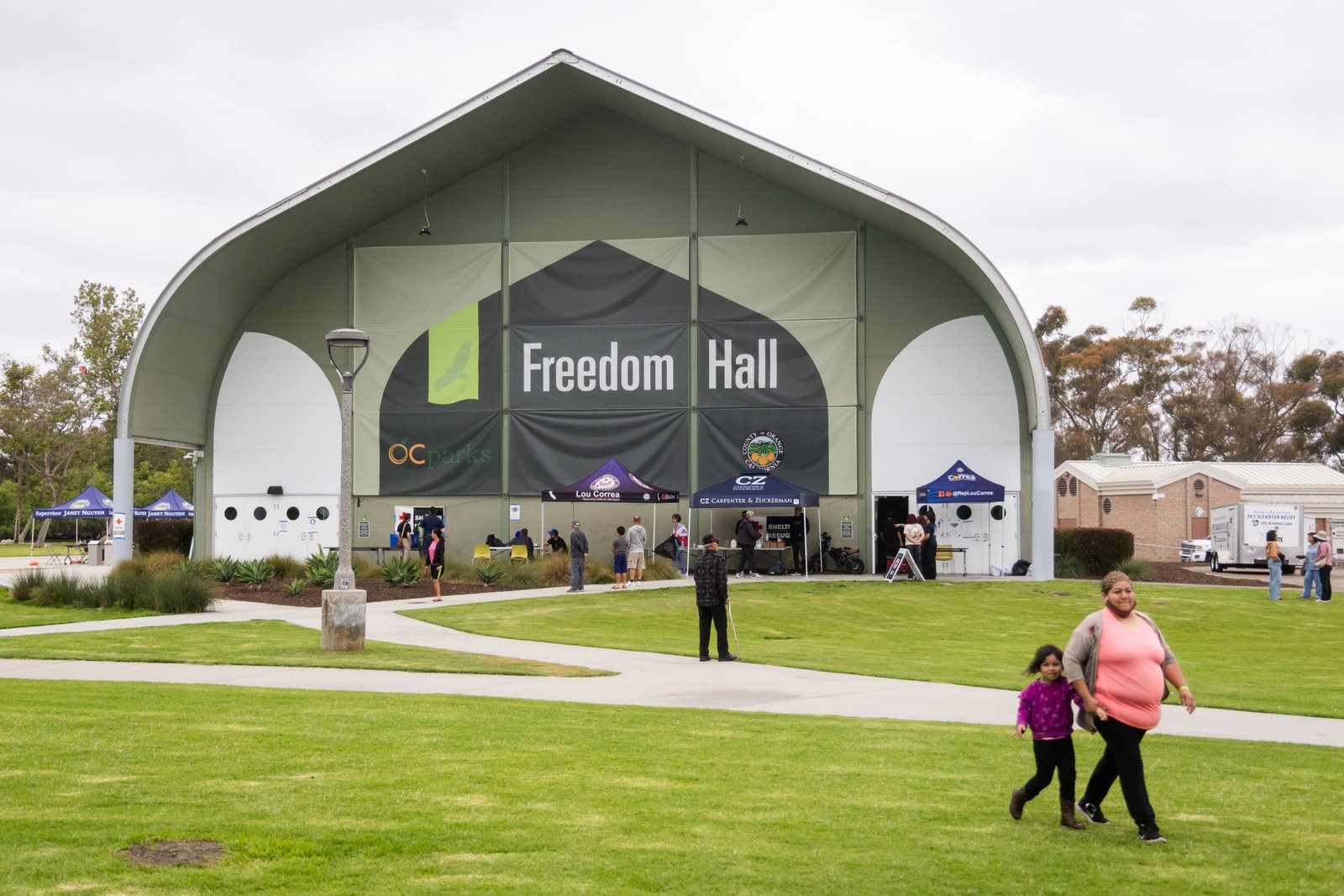 មនុស្សម្នាដើរនៅមុខ Freedom Hall ដែលជាមជ្ឈមណ្ឌលជម្លៀសនៅ Fountain Valley រដ្ឋកាលីហ្វ័រញ៉ា