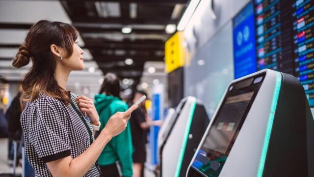1779795775_0_Woman-checking-flight-information-and-using-self-service-kiosk-at-airport-terminal.jpg