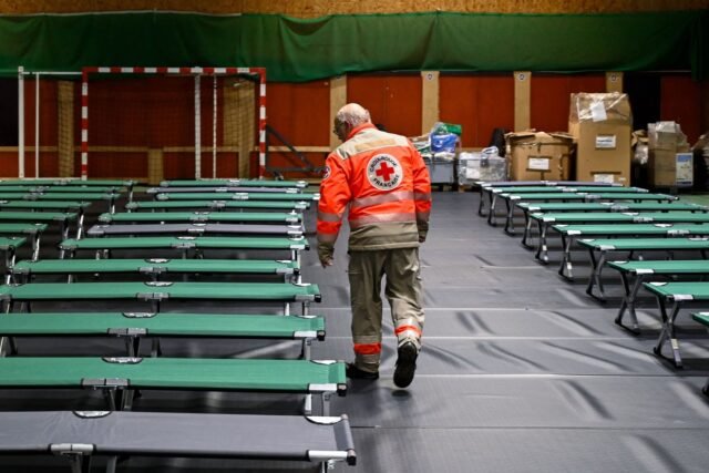 1779858113_2445517-un-benevole-de-la-croix-rouge-prepare-un-gymnase-a.jpg