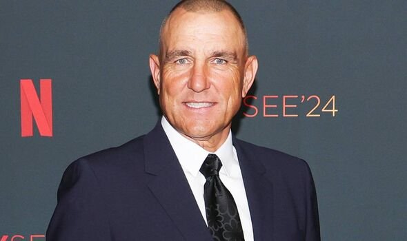 Vinnie Jones ក្នុង​ឈុត​ពណ៌​ខៀវ​ខ្មៅ និង​ក្រវាត់​ពណ៌​ខ្មៅ