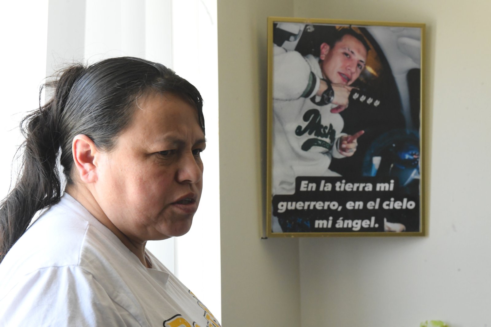 Adriana Garzon ម្តាយរបស់ Brayan Rayo Garzon ដែលបានស្លាប់ដោយការធ្វើអត្តឃាតខណៈពេលដែលនៅក្នុងមន្ទីរឃុំឃាំង ICE ក្នុងខែមេសាឆ្នាំ 2025 ឈរក្បែររូបថតរបស់ Rayo ដែលសរសេរថា: