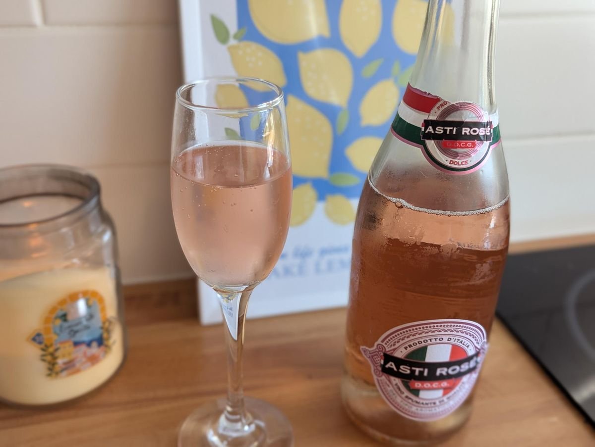 រូបភាពនៃដប Rose Asti ជាមួយនឹងកែវស្រា Sparkling នៅជាប់វា។
