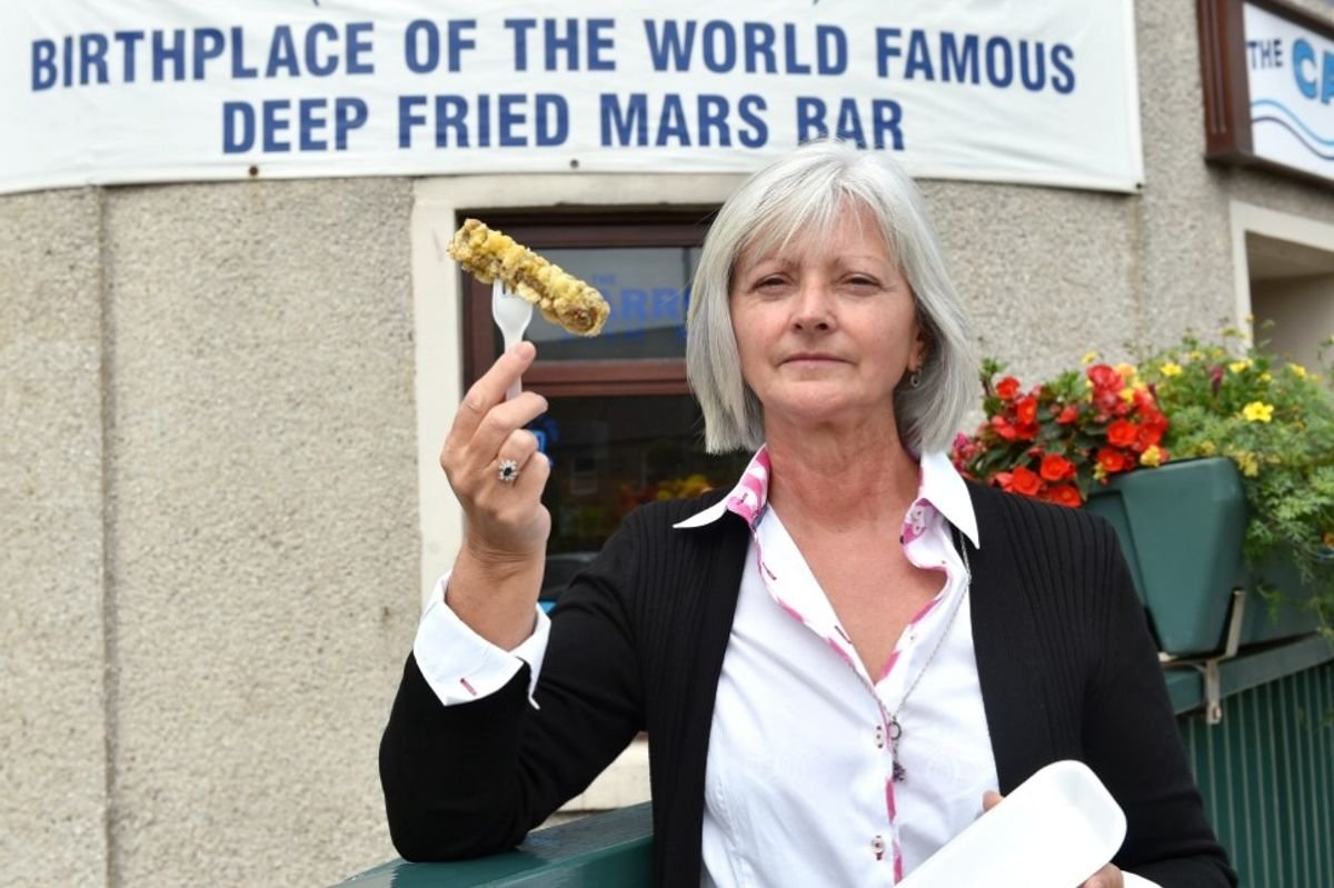 ម្ចាស់ Lorraine Watson នៅមុខ Carron Fish Bar ជាមួយនឹងរបារ Mars ដែលត្រូវបានវាយដំ។