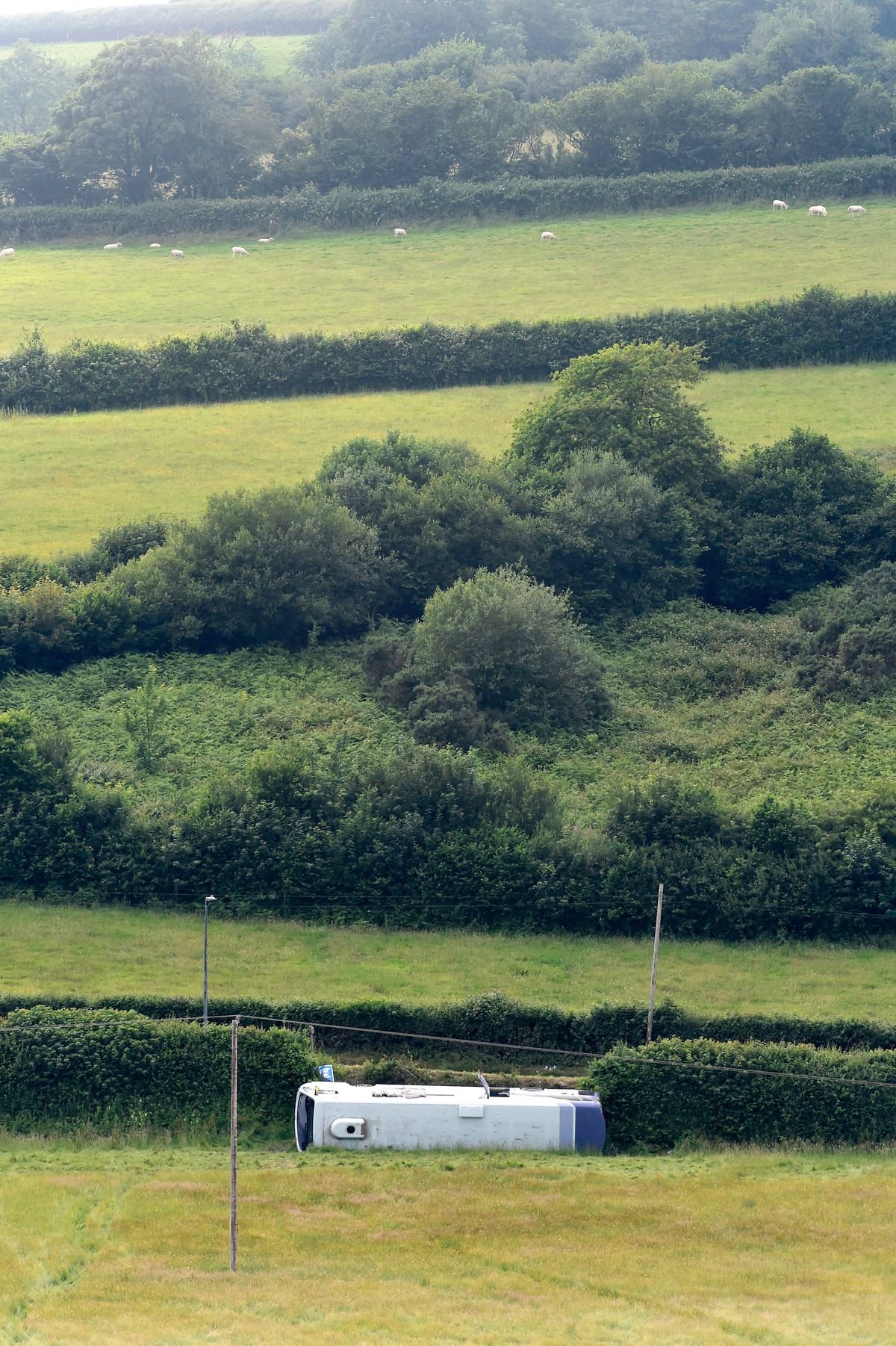 KIDWELLY, United Kingdom - ថ្ងៃទី 23 ខែមិថុនា: រថយន្តក្រុងមួយនៅចំហៀងខ្លួននៅក្នុងវាលមួយបន្ទាប់ពីឧប្បត្តិហេតុនៅលើ A484 នៅថ្ងៃទី 23 ខែមិថុនាឆ្នាំ 2026 នៅ Kidwelly, Wales ។ សេវាសង្គ្រោះបន្ទាន់កំពុងចូលរួមក្នុងគ្រោះថ្នាក់នៅលើផ្លូវ A484 ដែលតភ្ជាប់ Carmarthen ទៅ Llanelli ។ អ្នក​ដំណើរ​ទាំង​អស់​ត្រូវ​បាន​នាំ​យក​ទៅ​កាន់​កន្លែង​សុវត្ថិភាព ហើយ​មិន​មាន​អ្នក​ស្លាប់​ត្រូវ​បាន​គេ​រាយការណ៍​ឡើយ​។ (រូបថតដោយ Rebecca Naden / Getty Images)