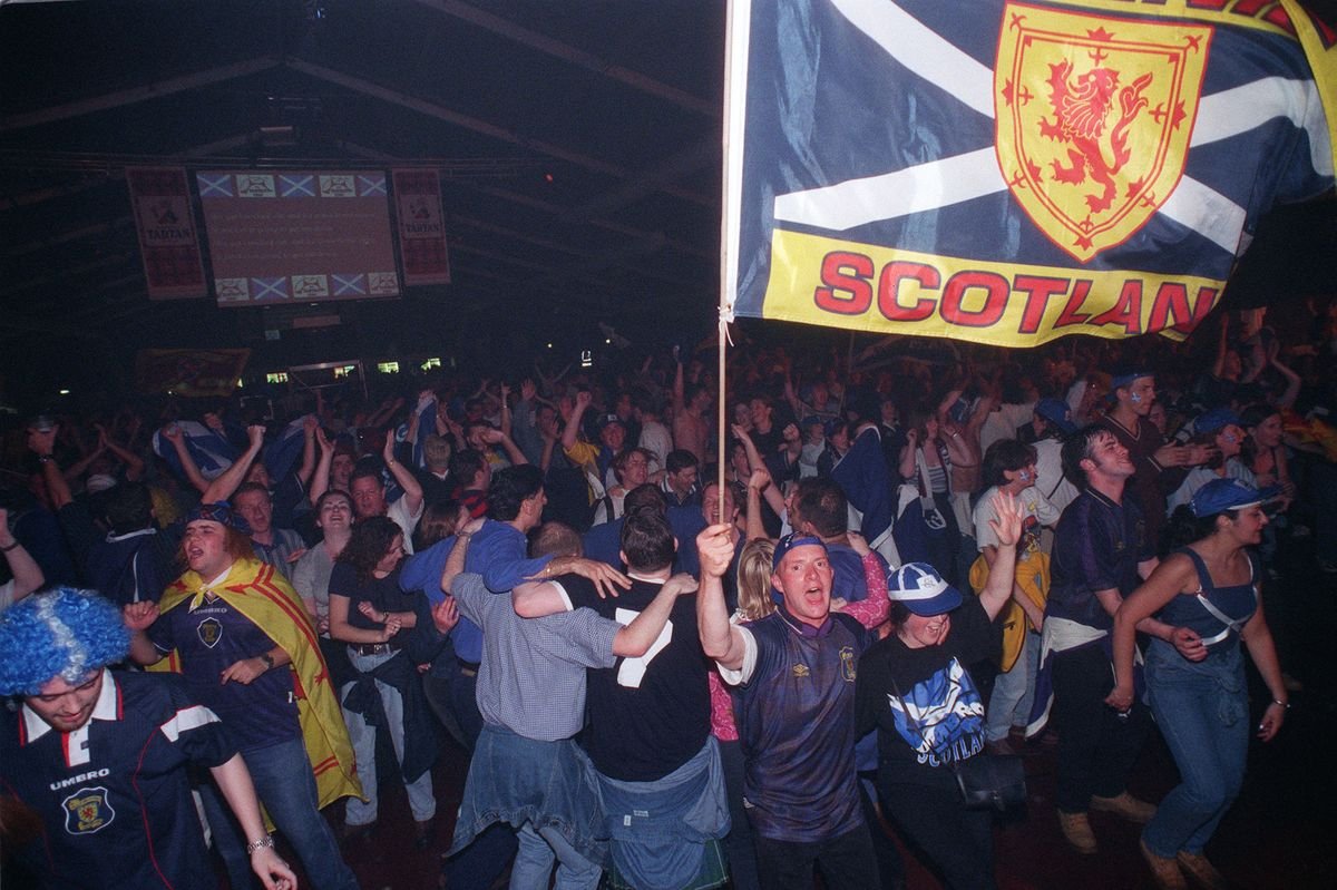 អ្នកគាំទ្រ Tartan Army Home Guard នៅក្នុងតង់ tartan នៅ Glasgow Green មើលហ្គេមឆ្នាំ 1998 នៅលើអេក្រង់ធំ
