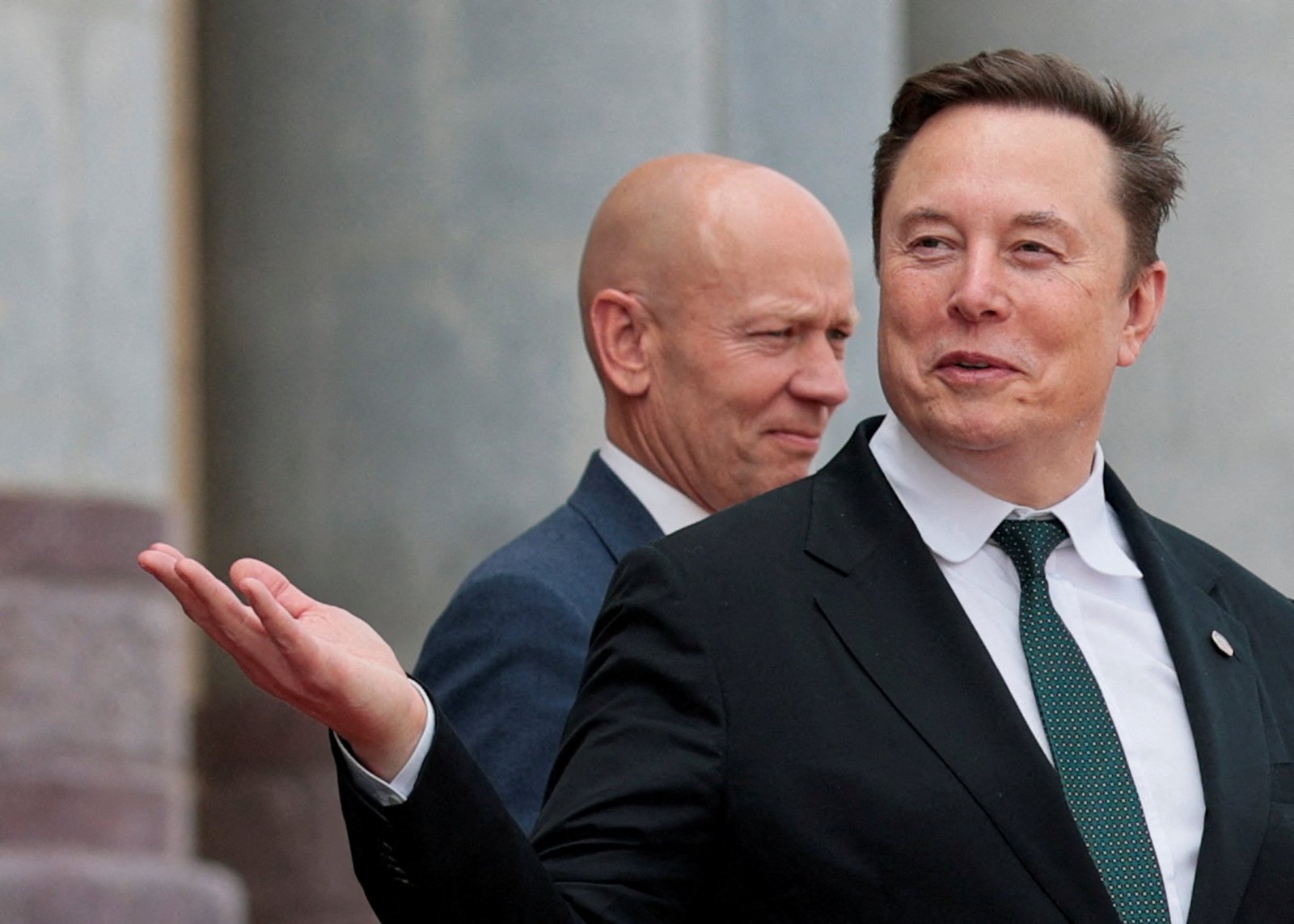 Elon Musk ធ្វើកាយវិការនៅពេលគាត់ចាកចេញបន្ទាប់ពីចូលរួមពិធីស្វាគមន៍ប្រធានាធិបតីអាមេរិក Donald Trump និងប្រធានាធិបតីចិន Xi Jinping នៅ Great Hall of the People ក្នុងទីក្រុងប៉េកាំង។