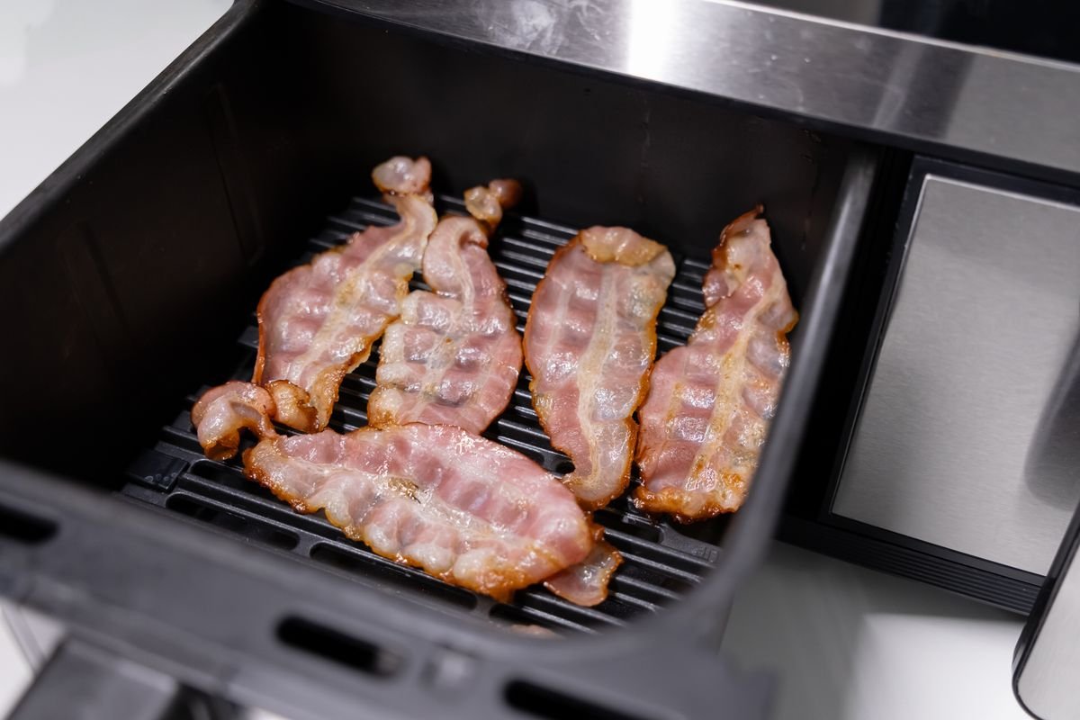 bacon ចៀនចម្អិននៅក្នុង fryer ខ្យល់មួយ។ bacon ចៀន។ ម្ហូបឆ្ងាញ់ៗក្នុងឡចំហាយក្តៅ។