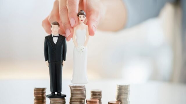 1784710978_0_Mixed-race-woman-balancing-bride-and-groom-statues-on-coin-stacks.jpg