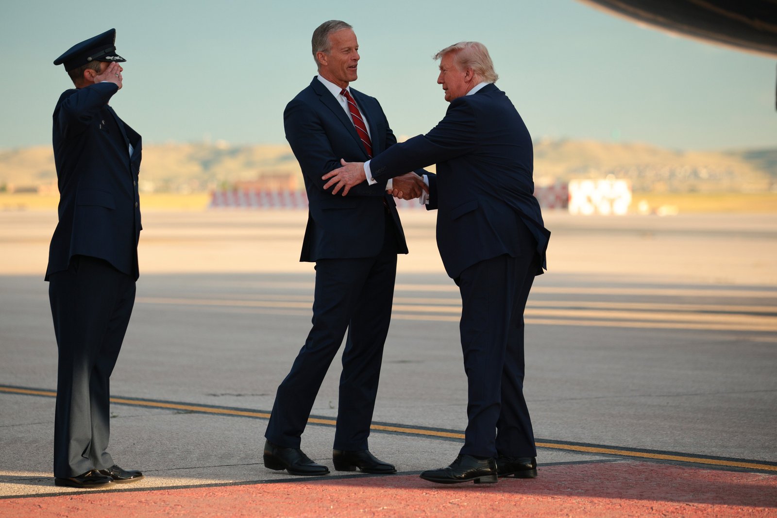 លោក Trump ត្រូវបានស្វាគមន៍ដោយមេដឹកនាំសំឡេងភាគច្រើនព្រឹទ្ធសភា លោក John Thune (R-SD) បន្ទាប់ពីបានចុះចតលើយន្តហោះ Air Force One នៅមូលដ្ឋានទ័ពអាកាស Ellsworth រដ្ឋ South Dakota ថ្ងៃទី 3 ខែកក្កដា ឆ្នាំ 2026។