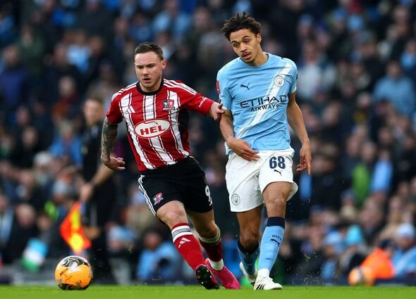 Max Alleyne របស់ Manchester City ត្រូវបានប្រជែងដោយ Jayden Wareham របស់ Exeter City អំឡុងពេល Emira