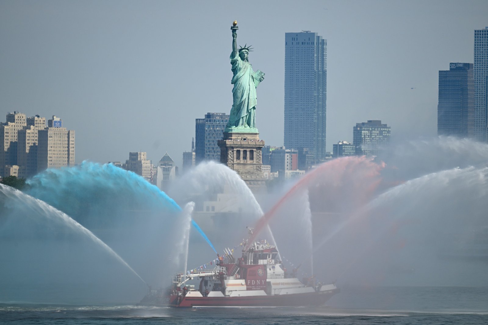 ទូក FDNY បាញ់​ទុយោ​របស់​ខ្លួន​ជា​កិត្តិយស​ដល់​រូបសំណាក​សេរីភាព​មុន​ការ​ដង្ហែ​ក្បួន​អន្តរជាតិ​នៃ​កប៉ាល់​ខ្ពស់ៗ​នៅ​កំពង់ផែ​ញូវយ៉ក​នៅ​ថ្ងៃ​ទី ៤ ខែ​កក្កដា ឆ្នាំ ២០២៦ ក្នុង​ទីក្រុង​ញូវយ៉ក។