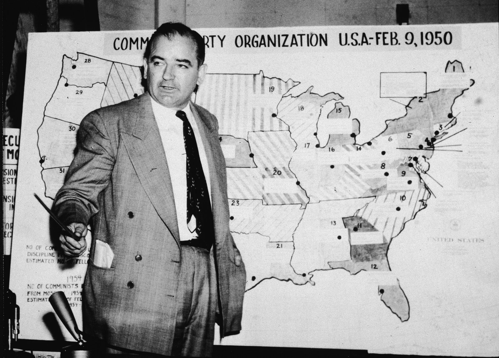 សមាជិកព្រឹទ្ធសភា Joe McCarthy ឈរនៅពីមុខផែនទីដែលពណ៌នាពីសកម្មភាពកុម្មុយនិស្តនៅសហរដ្ឋអាមេរិកក្នុងរដូវក្តៅឆ្នាំ 1954