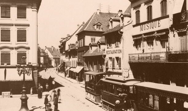 នៅទីនេះ រថភ្លើងចំហុយ rue du Sauvage នៅ Place des Victoires ក្នុងឆ្នាំ 1885។ ក្រុមហ៊ុន Tramways Mulhouse (TM) ត្រូវបានបង្កើតឡើងនៅថ្ងៃទី 21 ខែមិថុនា ឆ្នាំ 1884 ដោយគ្មានការឧបត្ថម្ភធន។ ឯកសារដឹកជញ្ជូនសាធារណៈរបស់ Mulhouse (TCM)